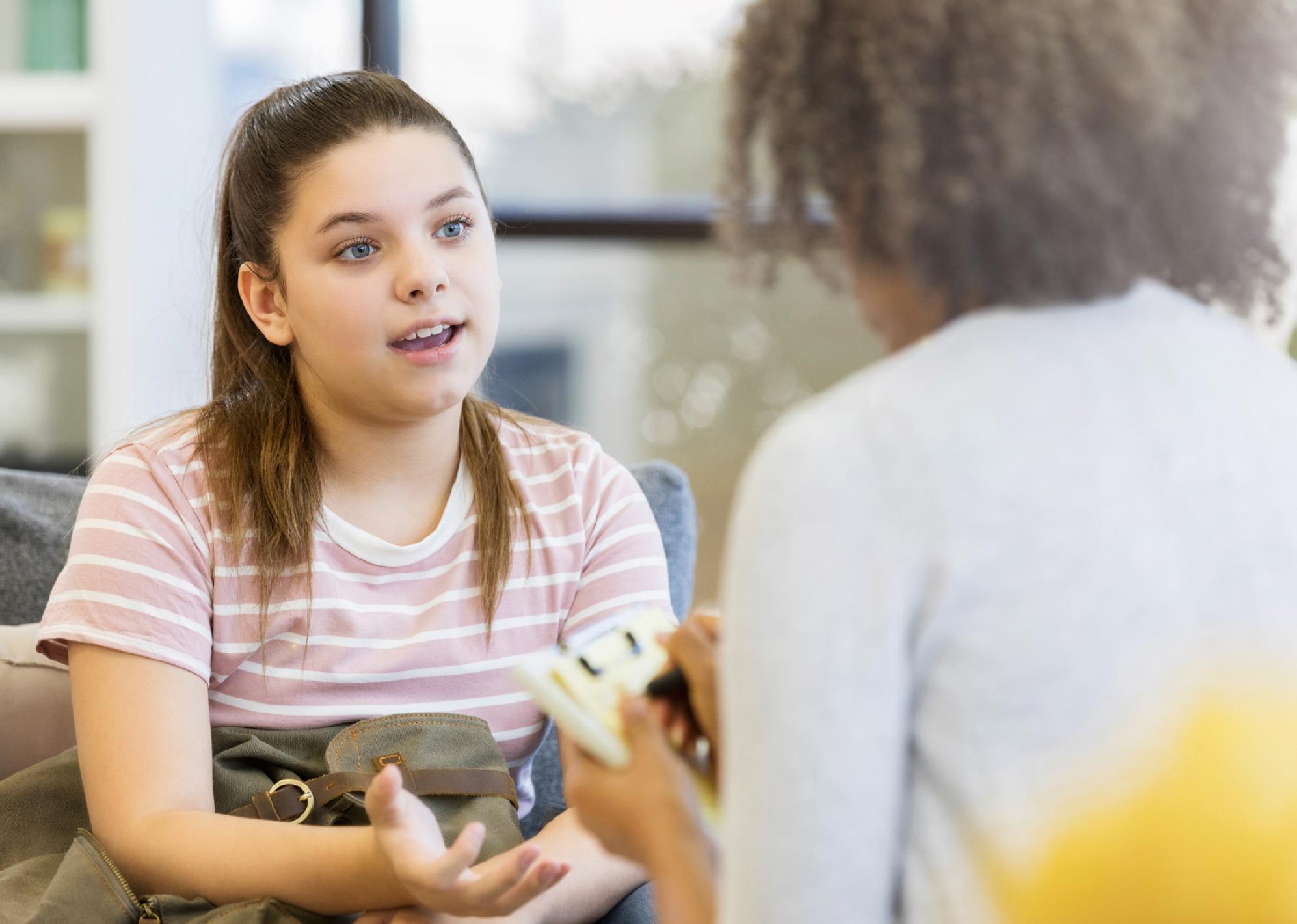 young girl speaking to a woman