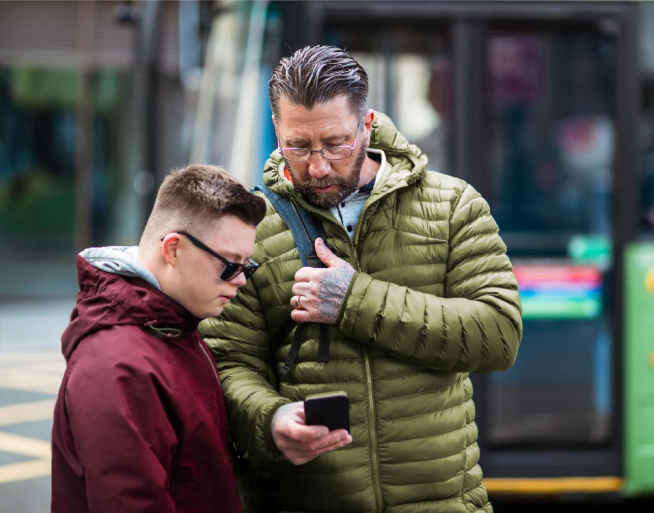 man and boy with bus in background