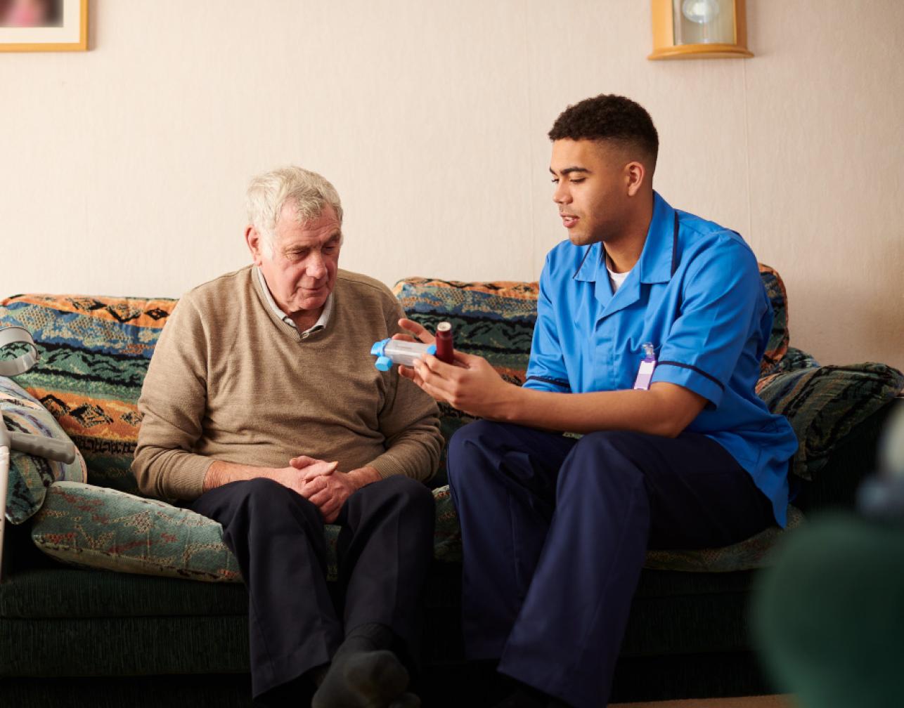 Elderly man and a nurse on a sofa