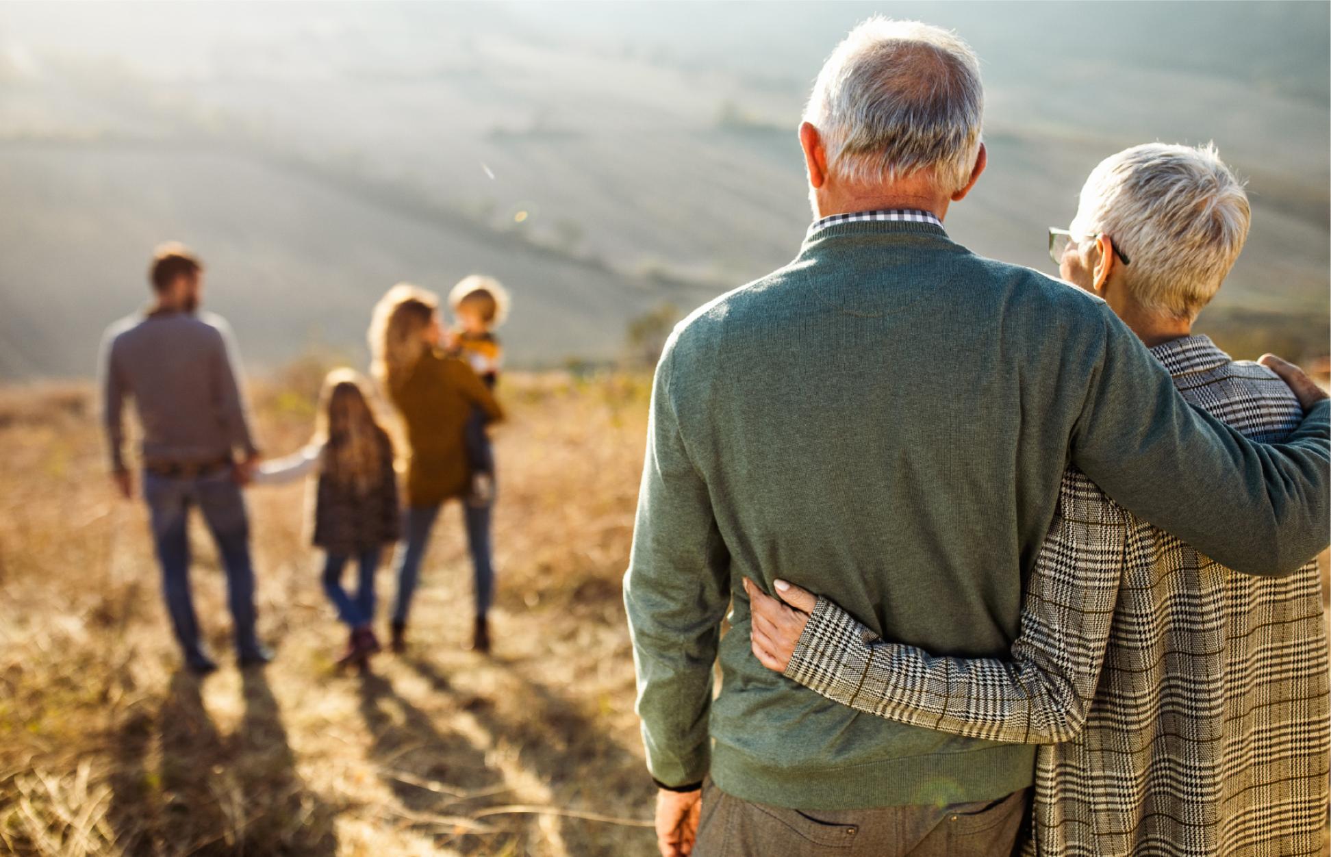 People embracing on a hill looking at the view