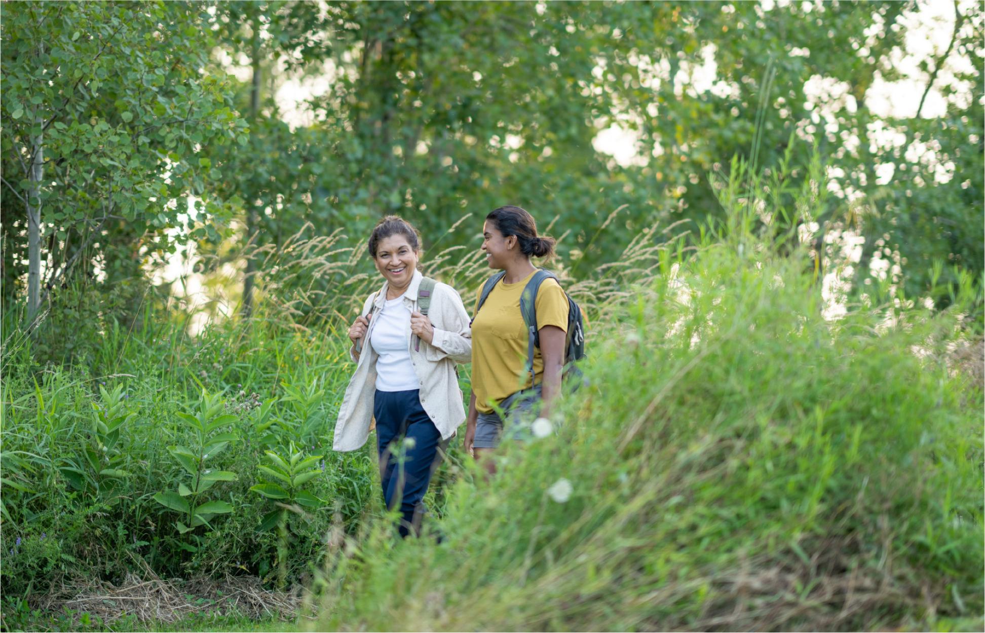Two women walking in a wooded area