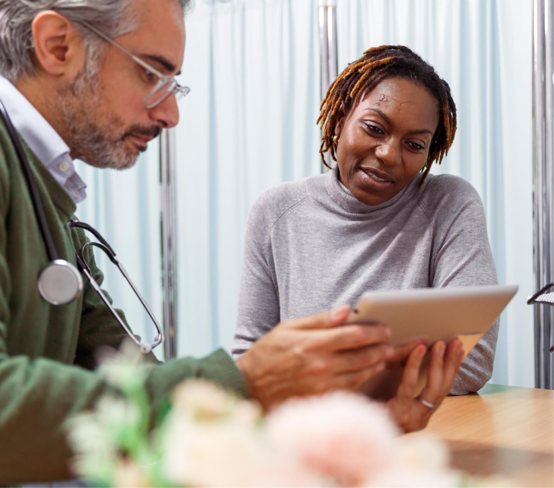 A health professional and a women looking at a tablet device